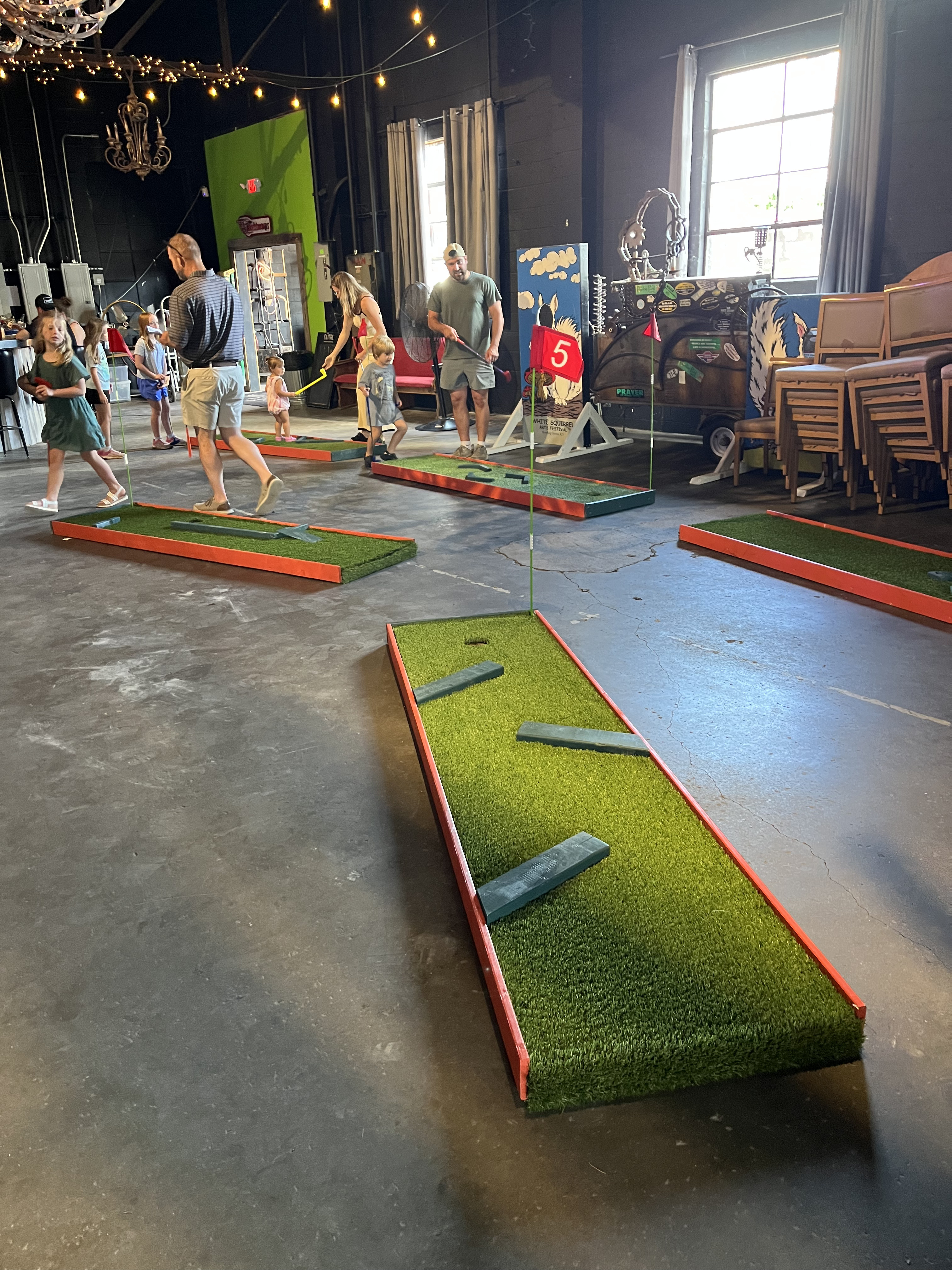Guests playing The Fun Forge portable mini golf at an indoor event